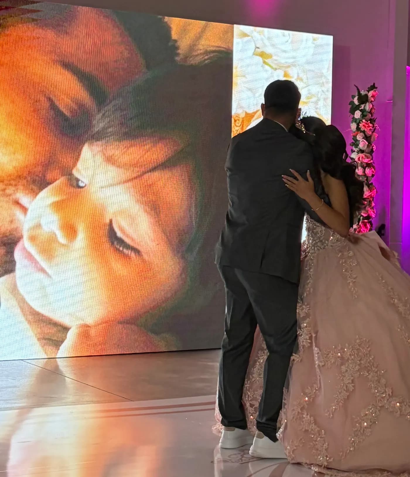 Alian dancing with his daughter Alissa at her quinceañera, with a photo of them from when she was little on the screen behind them
